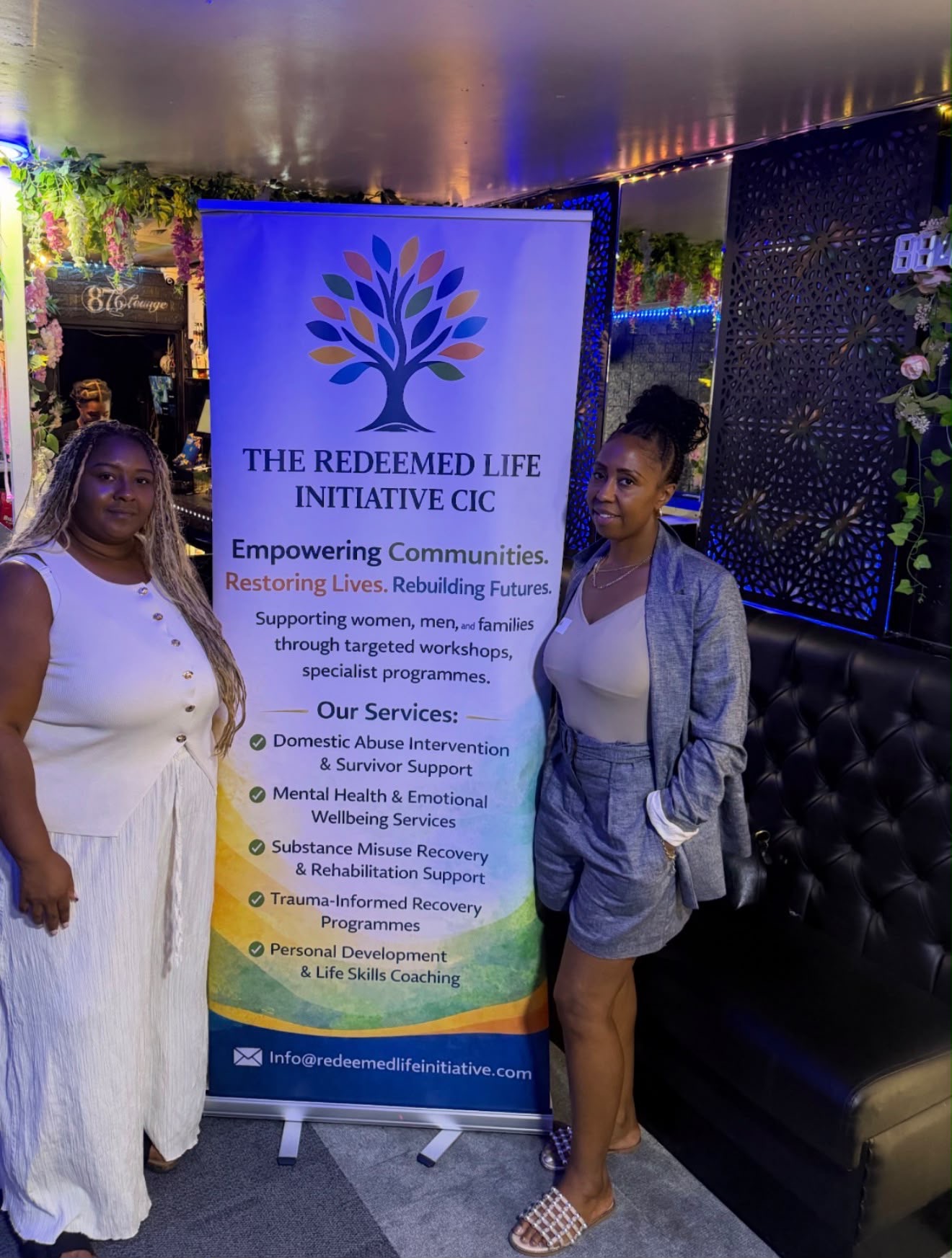 The Redeemed Life Initiative CIC leadership beside the organisation banner
