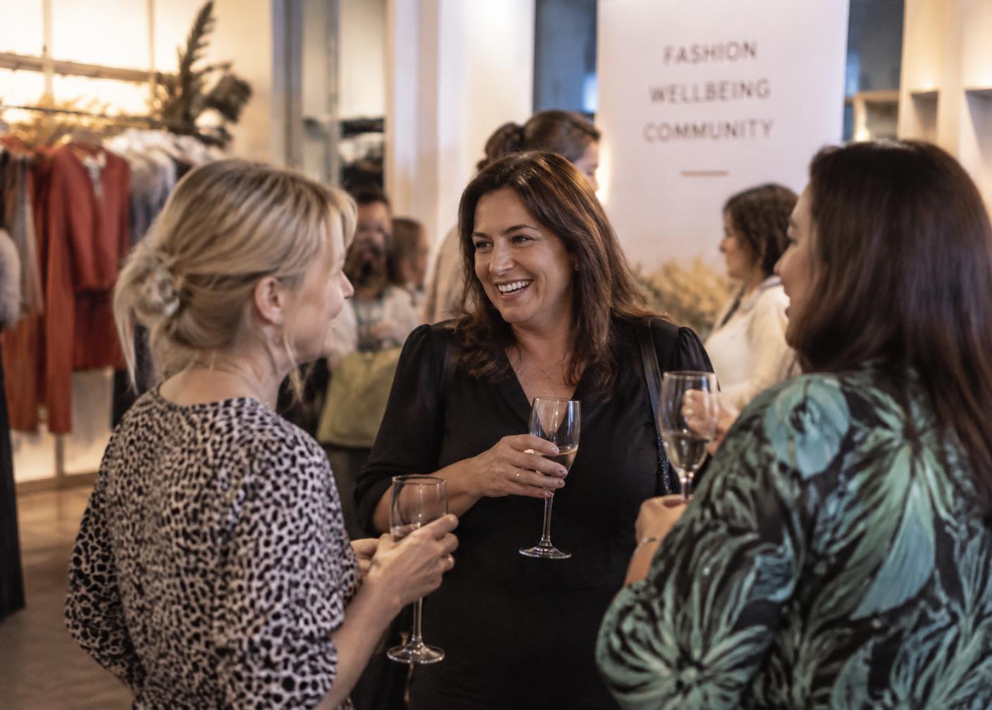 Guests talking and smiling together at the fashion and wellbeing evening